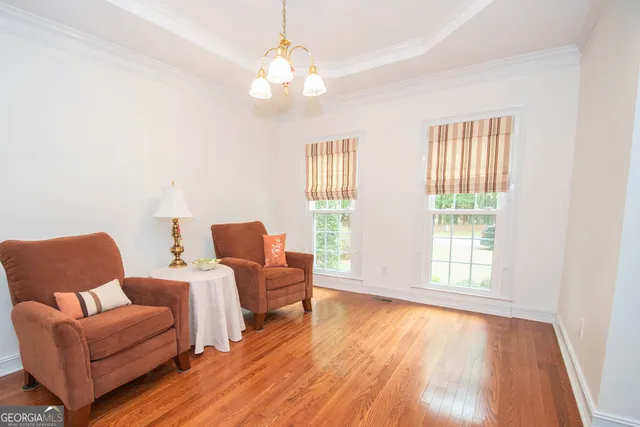 a view of a a dining room with furniture window and wooden floor