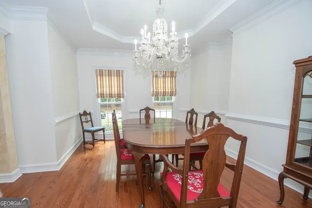 a dining room with furniture a chandelier and wooden floor