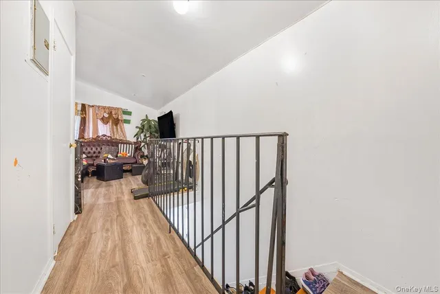 a view of a hallway with wooden floor and dining room view