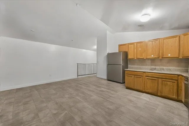 a kitchen with granite countertop a refrigerator a sink and dishwasher