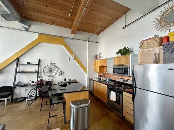 a kitchen with stainless steel appliances a stove a chimney a sink and cabinets