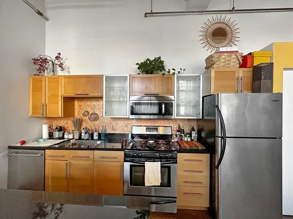 a kitchen with stainless steel appliances granite countertop a sink and a stove