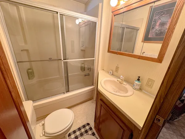 a bathroom with a sink a toilet a tub and shower