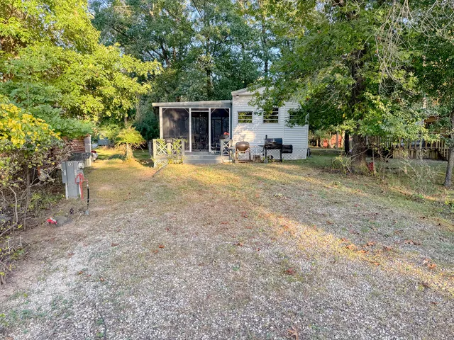 a view of a house with backyard and a tree