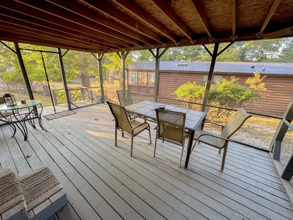 a view of a chairs and table in patio with wooden floor