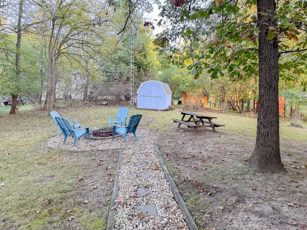 a view of a backyard with table and chairs under an umbrella