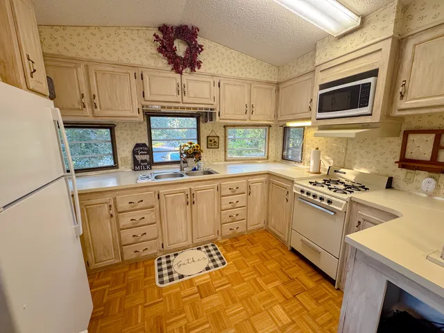 a kitchen with stainless steel appliances granite countertop a sink a stove a microwave and cabinets