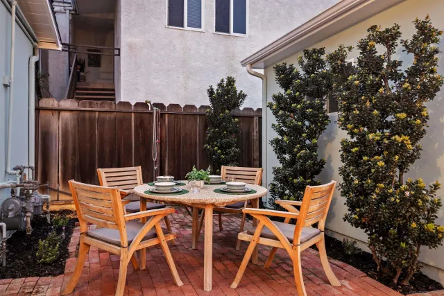 a view of a patio with table and chairs with wooden floor and fence