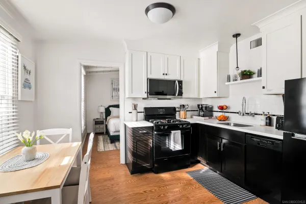 a kitchen with granite countertop a sink appliances and cabinets