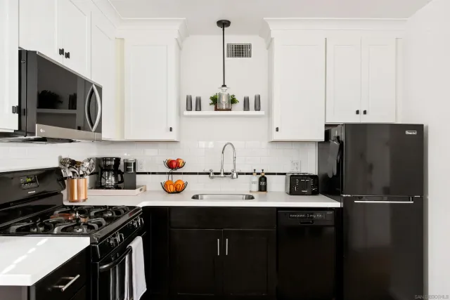 a kitchen with stainless steel appliances a stove a sink and a refrigerator