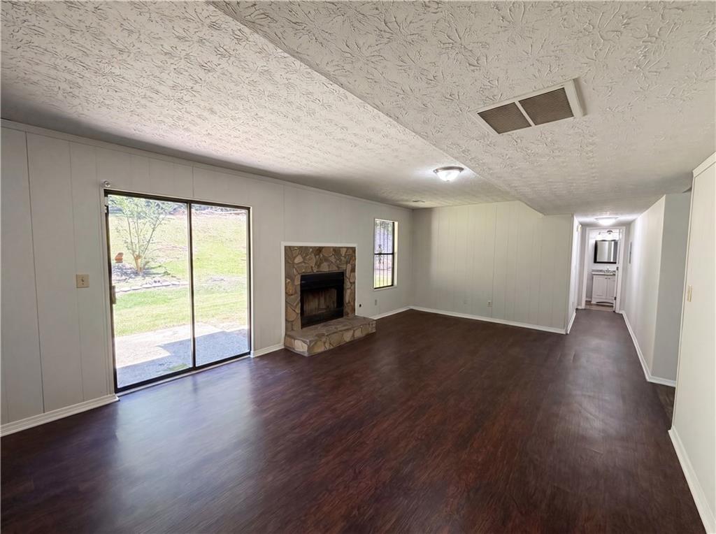 6830 Earlhurst Road Atlanta, GA 30349 - Photo 7 of 27 an empty room with wooden floor fireplace and windows