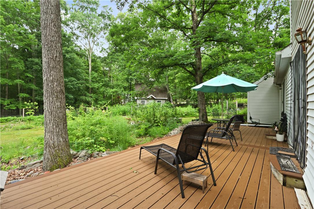 209 Remington Road East Stroudsburg, PA 18301 - Photo 4 of 41 An inviting deck extends into a lush, private yard surrounded by mature trees.