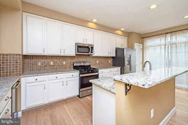 a kitchen with stainless steel appliances granite countertop a stove a sink dishwasher and a refrigerator