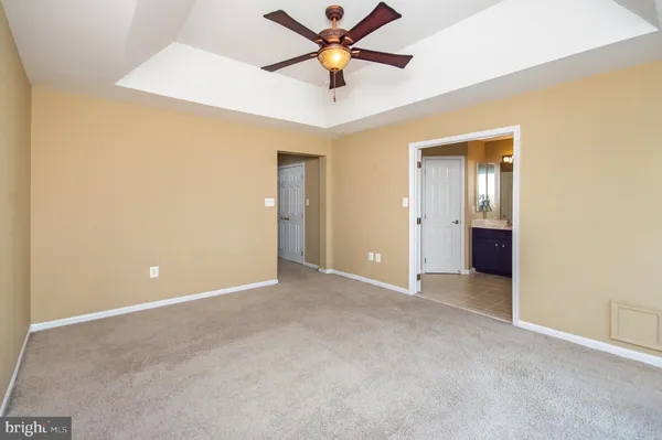 an empty room with closet and a chandelier fan