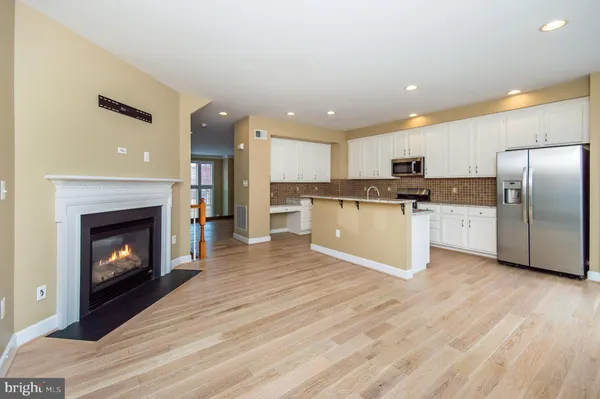 a view of kitchen with wooden floor and a fireplace