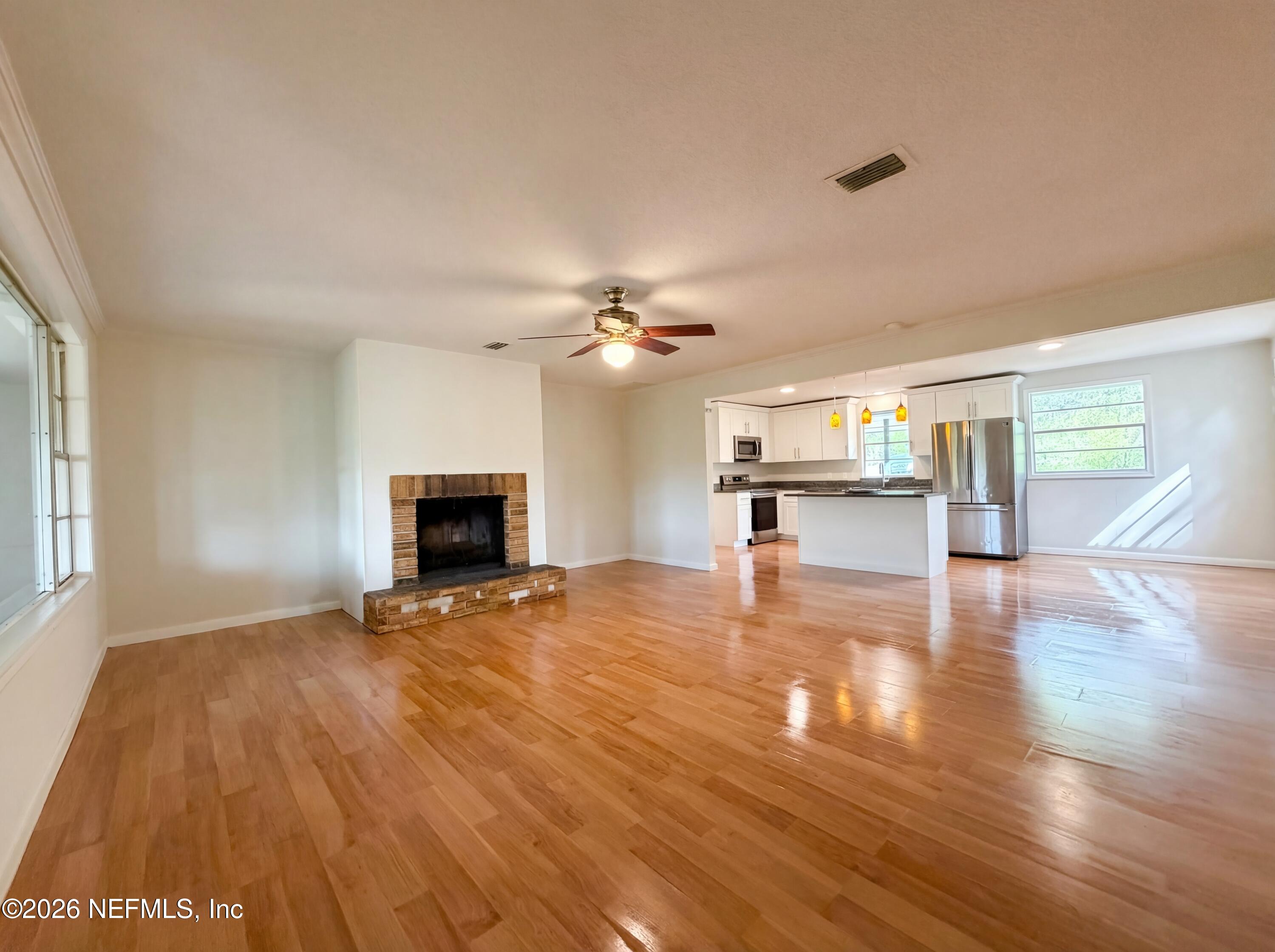 6917 Gatorbone Road Keystone Heights, FL 32656 - Photo 5 of 24 a view of empty room with wooden floor and fireplace