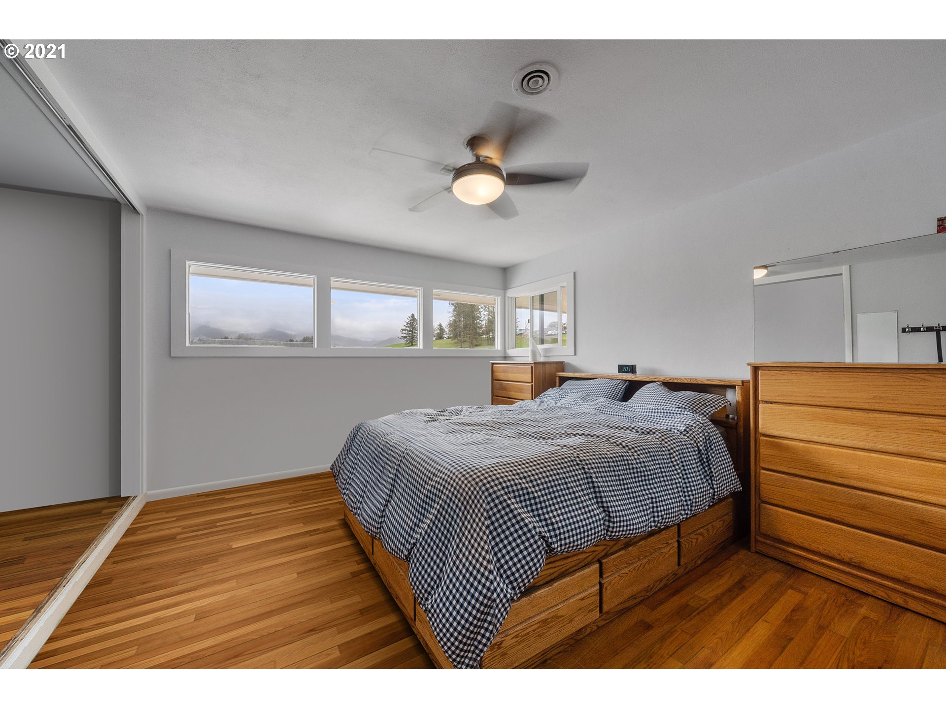 1220 McCormick Loop Road Tillamook, OR 97141 - Photo 25 of 30 a bedroom with a bed and a dresser with rug