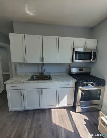 a kitchen with stainless steel appliances a stove a microwave a sink and cabinets