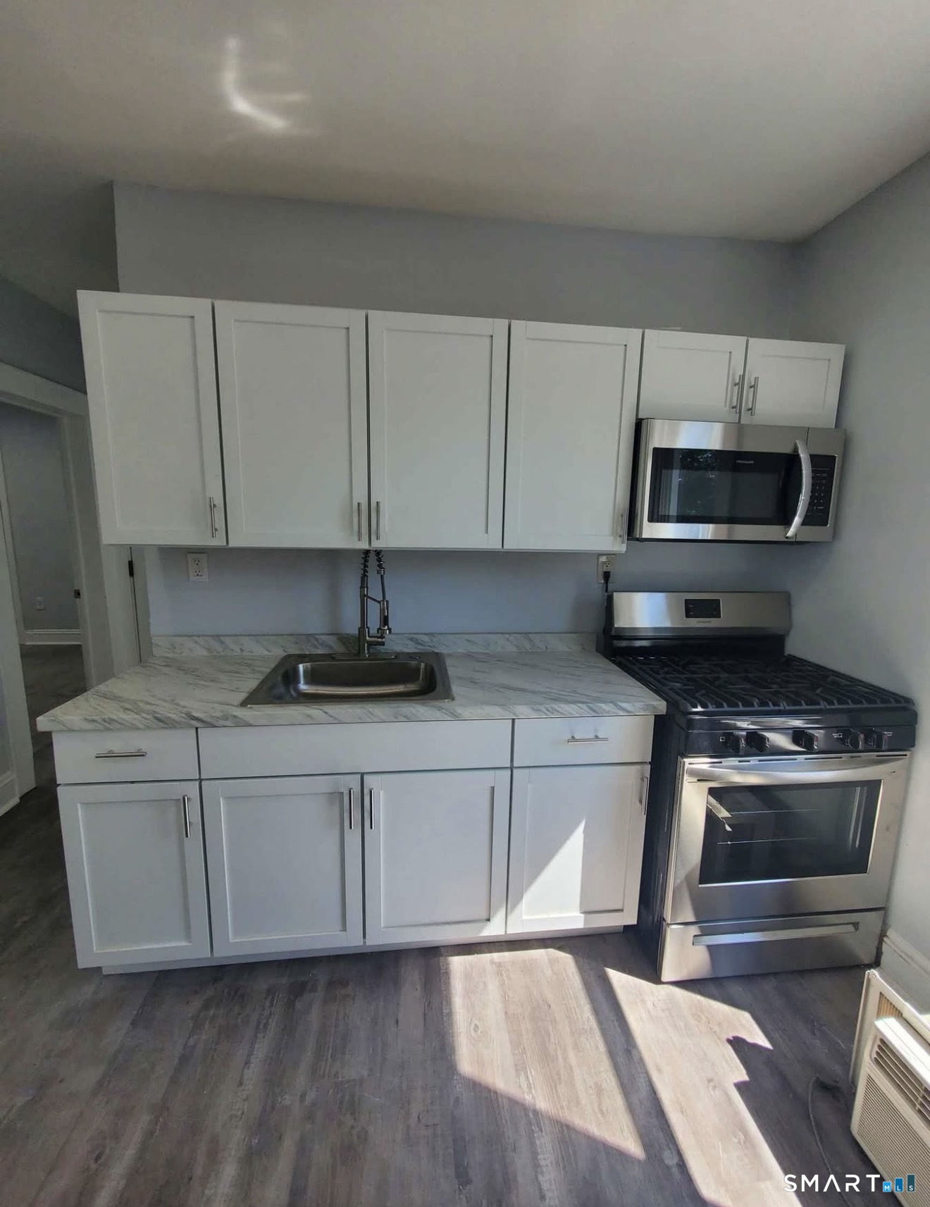100 Horace Street Bridgeport, CT 06610 - Photo 1 of 8 a kitchen with stainless steel appliances a stove a microwave a sink and cabinets