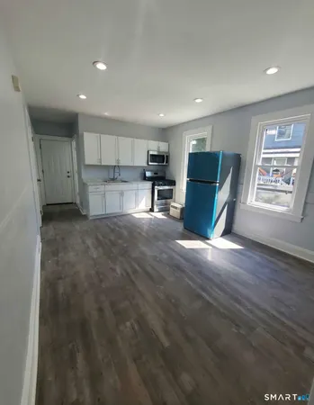 a view of kitchen with kitchen island microwave and wooden floor