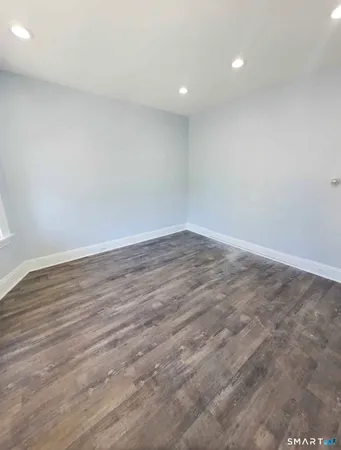 a view of an empty room with wooden floor