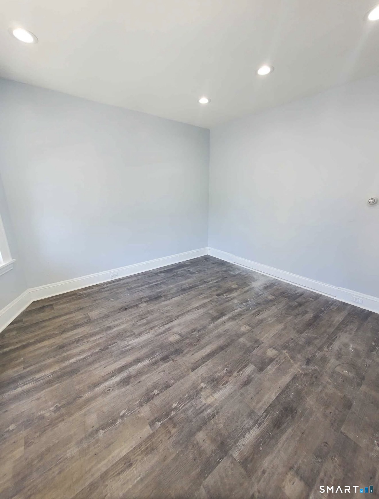 100 Horace Street Bridgeport, CT 06610 - Photo 3 of 8 a view of an empty room with wooden floor