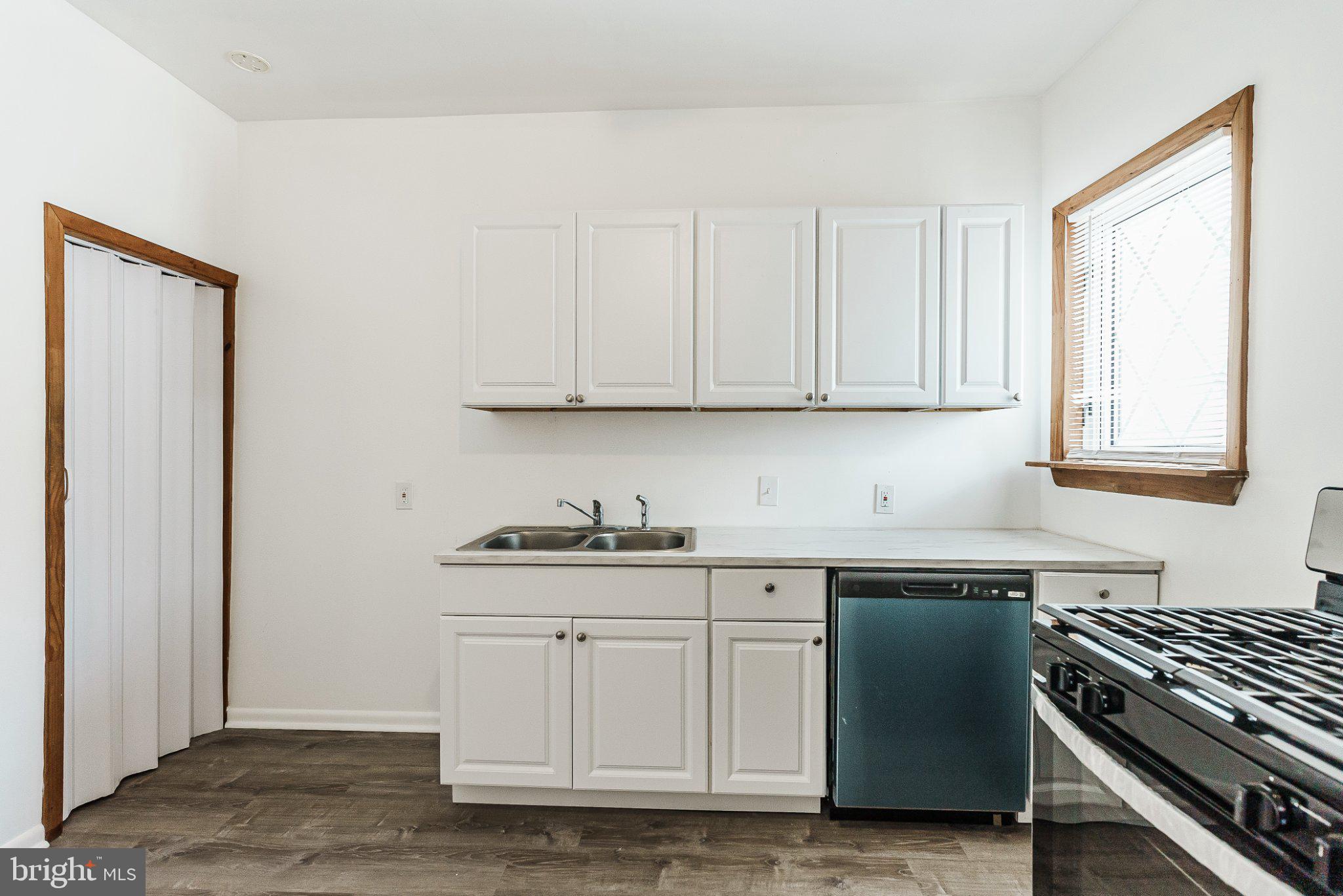 724 Moyer Street Philadelphia, PA 19125 - Photo 12 of 25 a kitchen with white cabinets and a stove