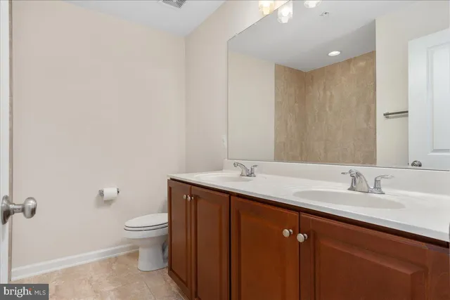 a bathroom with a toilet sink and mirror