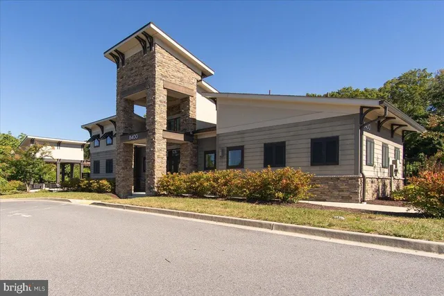 an aerial view of a residential houses with outdoor space and trees all around