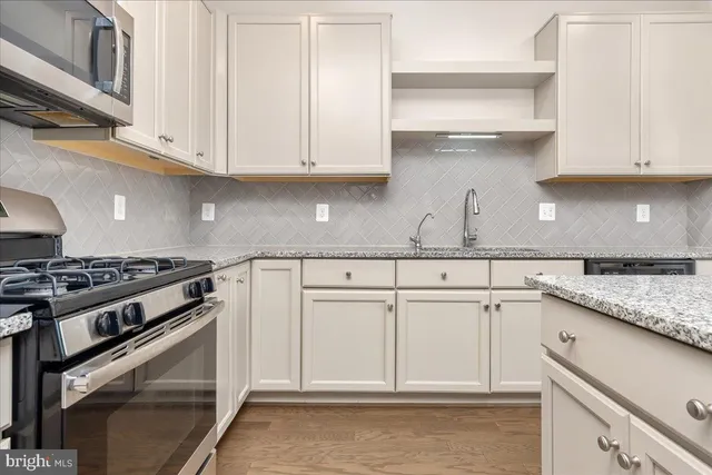 a kitchen with white cabinets and appliances