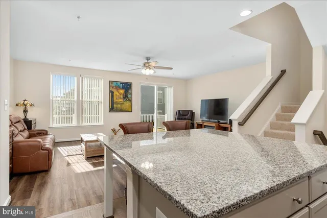 a view of living room with granite countertop couches a fireplace with wooden floor