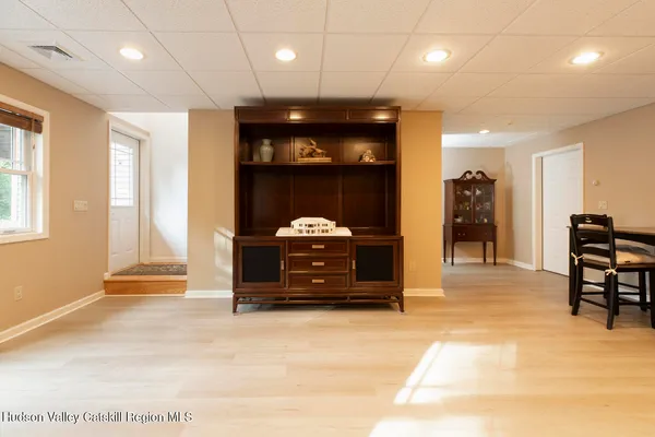 a view of a big room with wooden floor and windows