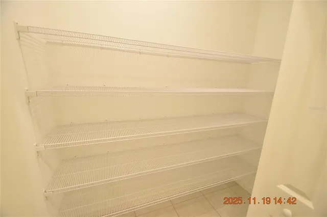 an empty room with closet and a chandelier fan