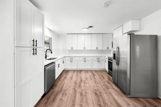 a large kitchen with cabinets stainless steel appliances and a counter space