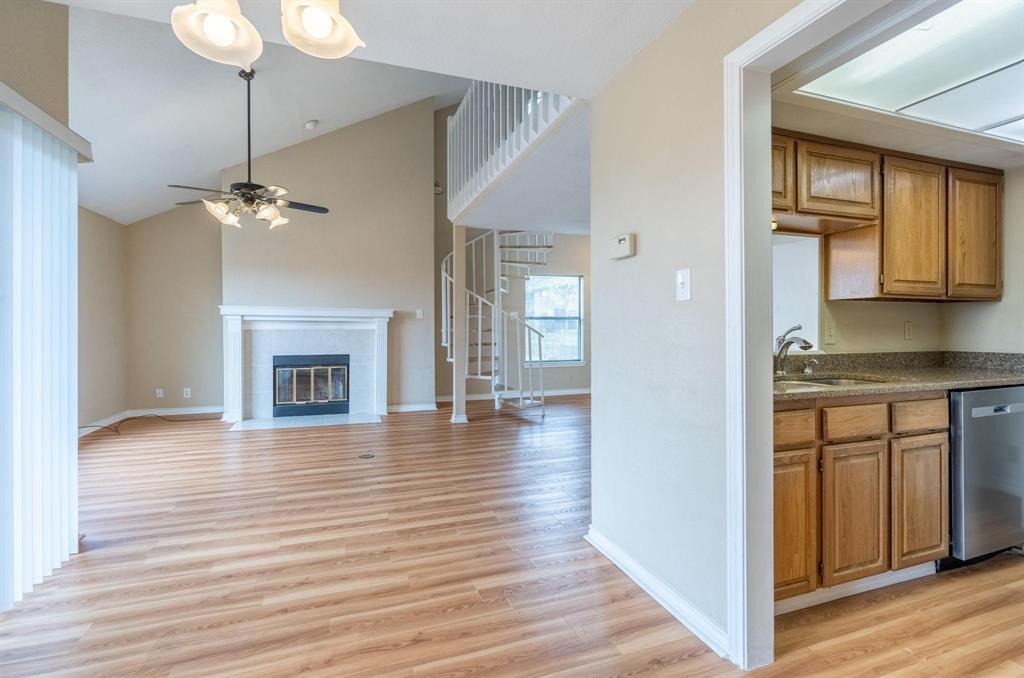 1518 Signal Ridge Place Rockwall, TX 75032 - Photo 5 of 13 Spacious living area featuring wood-finish flooring, a vaulted ceiling, and a fireplace with a white mantel