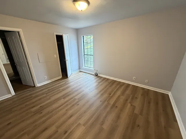 an empty room with wooden floor and chandelier fan