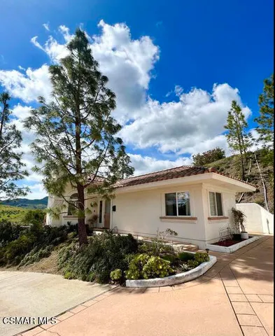 a view of a house with backyard and sitting area
