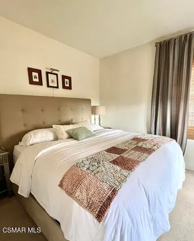 a bedroom with a bed and painting on the wall