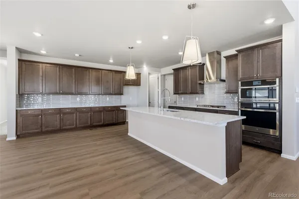a large kitchen with a large counter top stainless steel appliances and cabinets