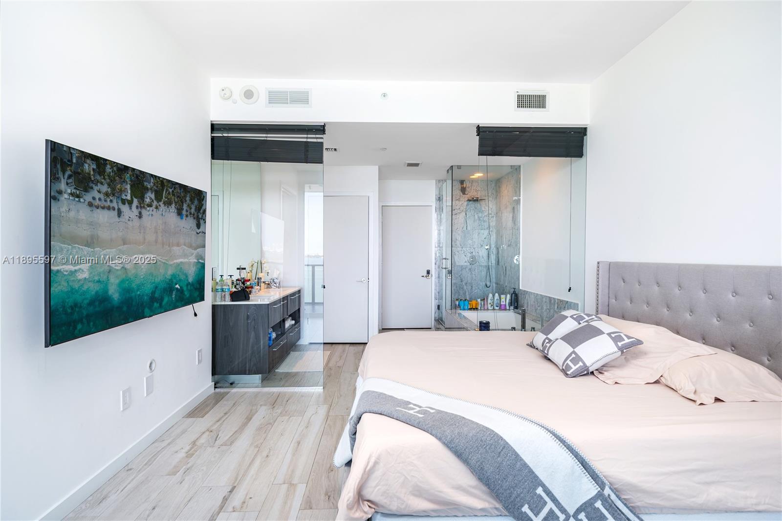 480 Northeast 31st Street, Unit 1603 Miami, FL 33137 - Photo 10 of 14 a bedroom with a bed and a flat screen tv