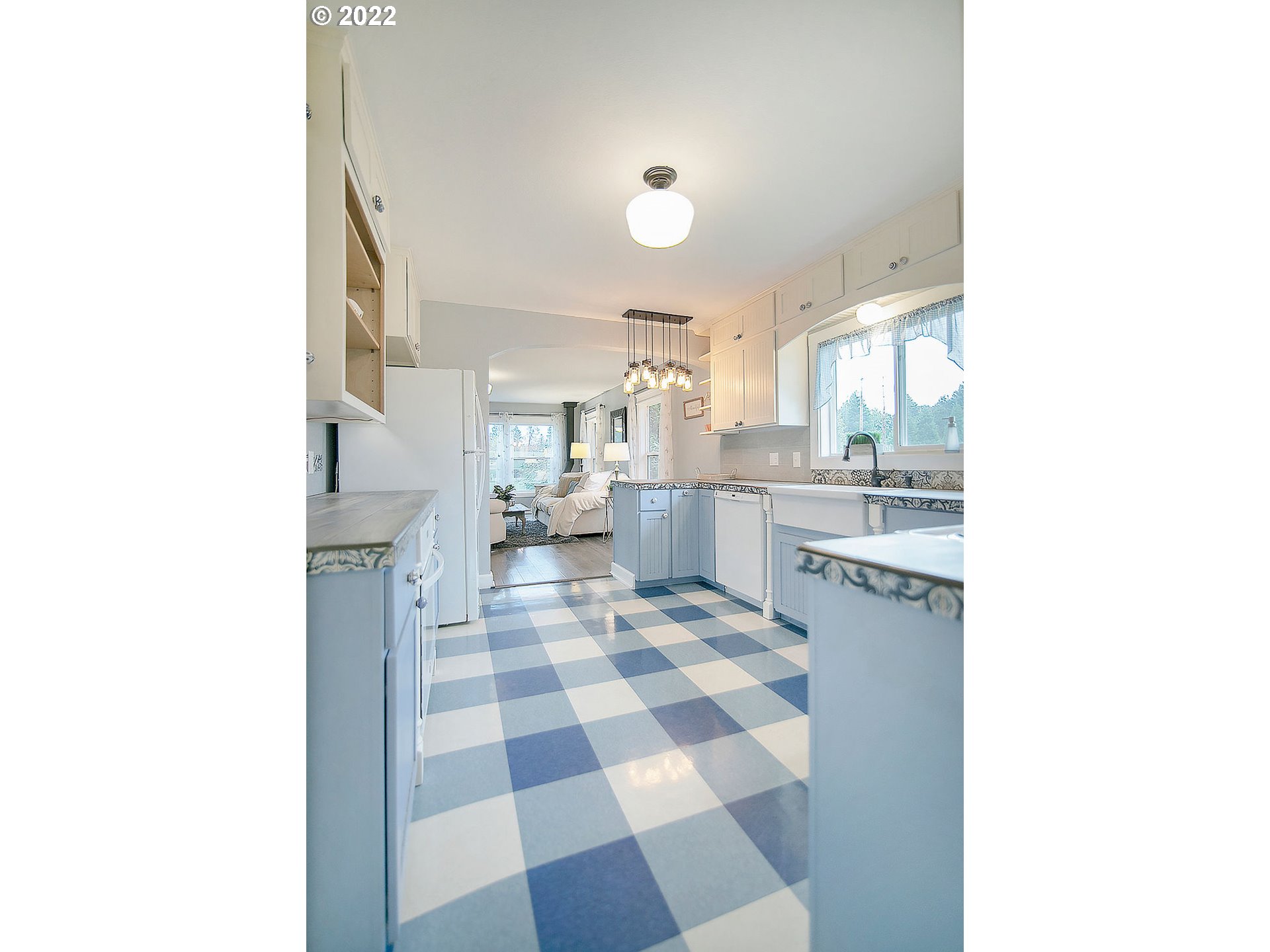 121 Rarey Road Winlock, WA 98596 - Photo 10 of 32 a kitchen with a checkered floor and white cabinets