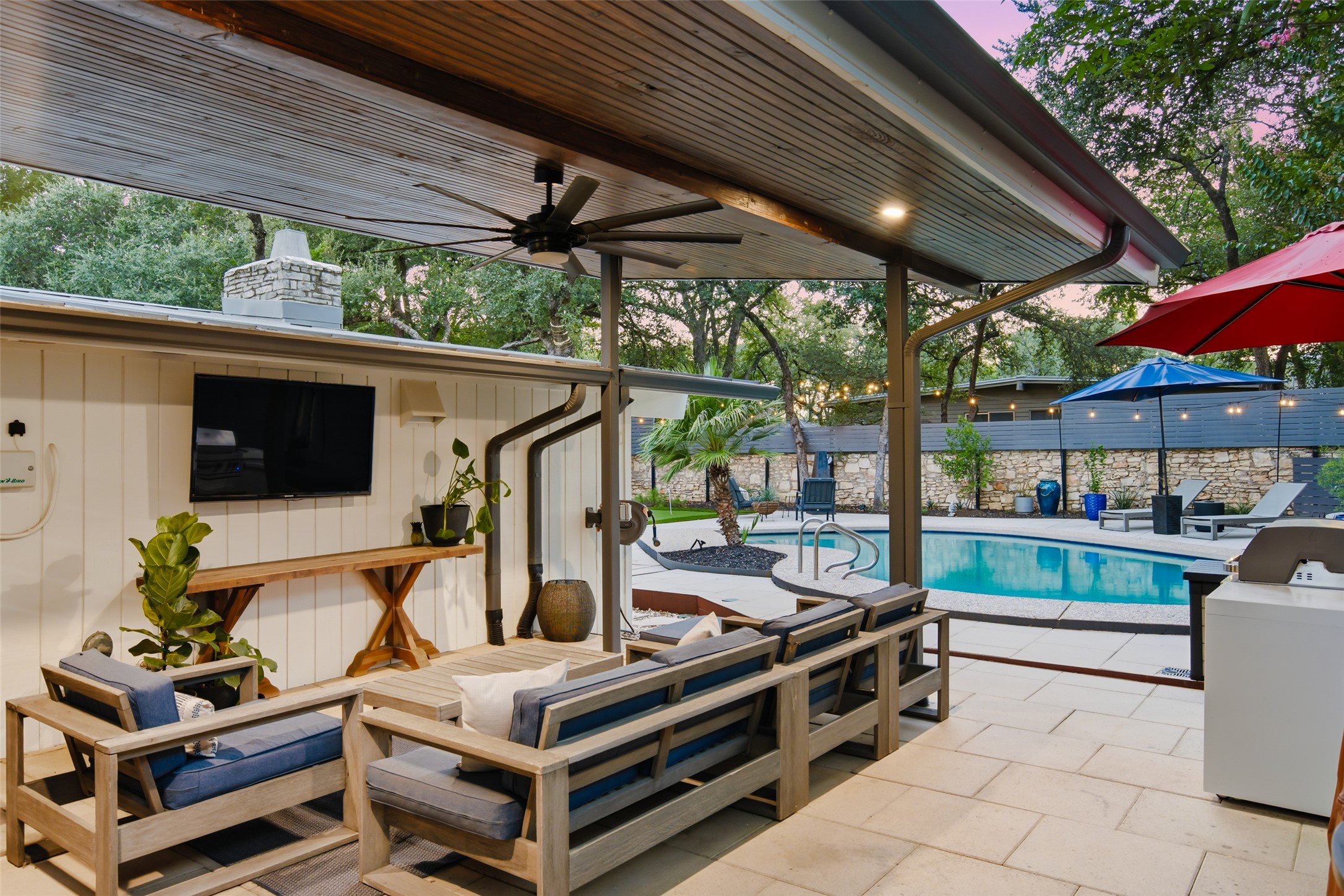412 Ridgewood Road West Lake Hills, TX 78746 - Photo 32 of 40 An inviting covered patio offers a comfortable lounging area beside the sparkling swimming pool.
