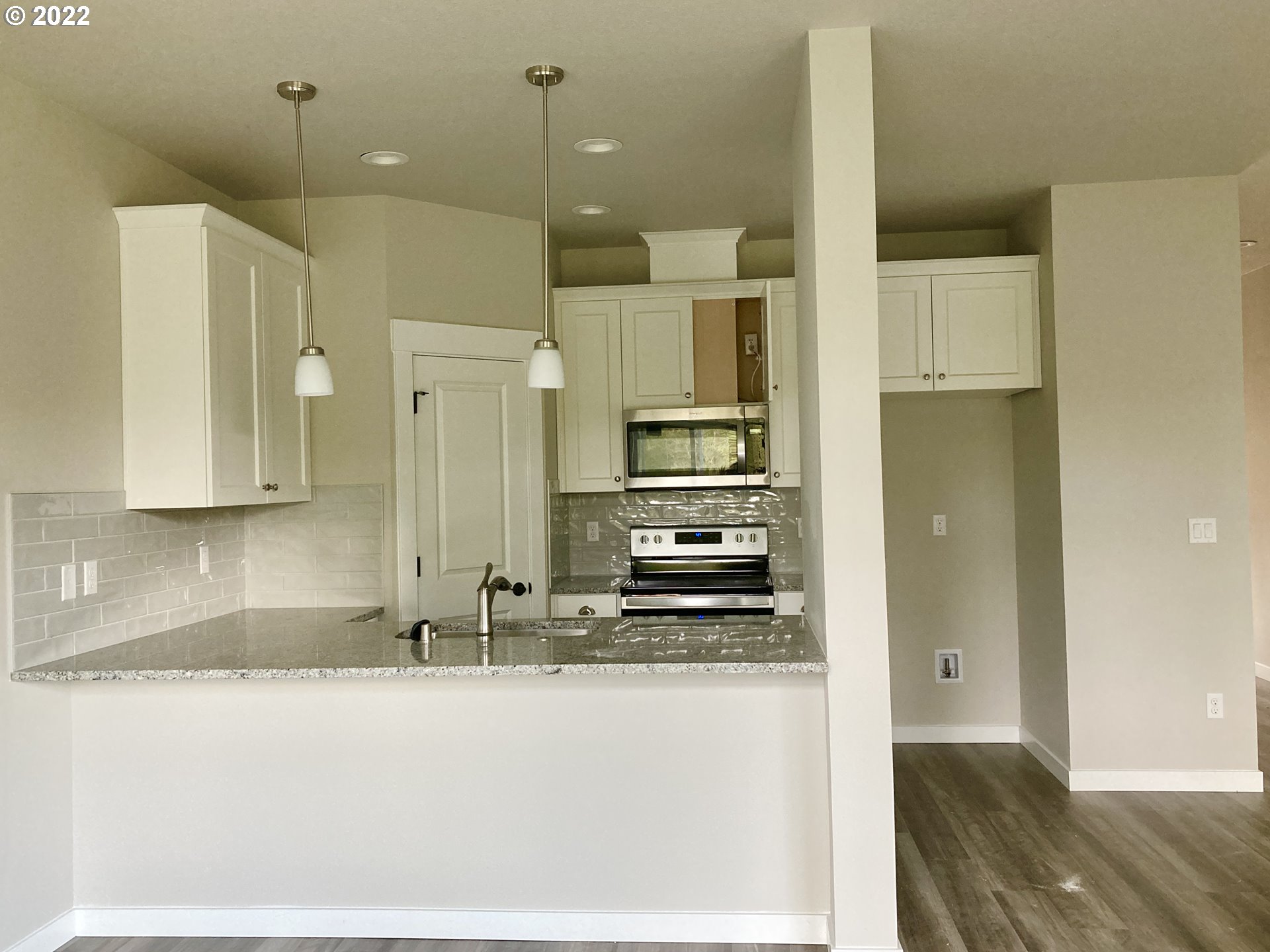 7241 South 13th Street Ridgefield, WA 98642 - Photo 2 of 2 a kitchen with kitchen island granite countertop a sink and refrigerator