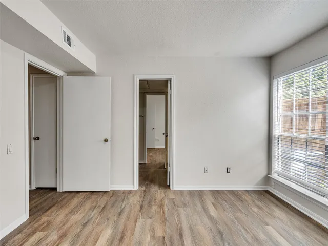 a view of a room with wooden floor and window