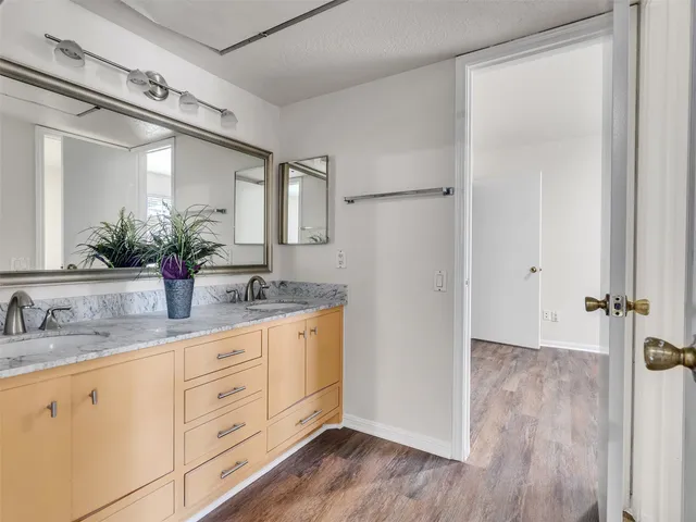 a bathroom with a double vanity sink mirror and shower