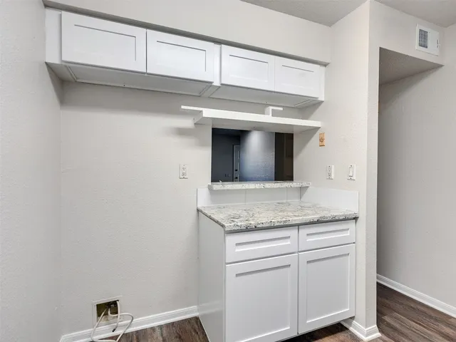 a bathroom with a granite countertop sink and white cabinets
