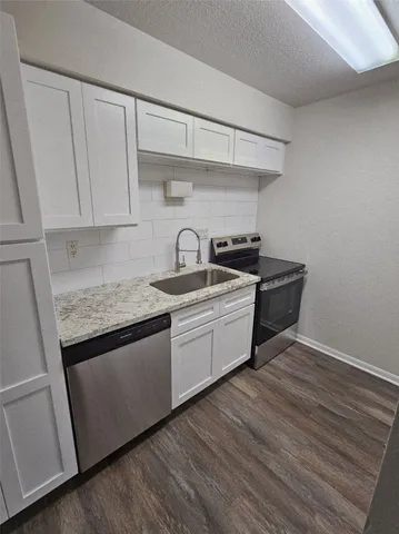 a kitchen with granite countertop a sink and cabinets