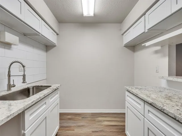 a kitchen with granite countertop a sink and cabinets