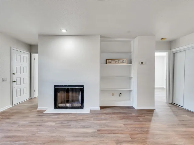 a view of an empty room with a fireplace and a window