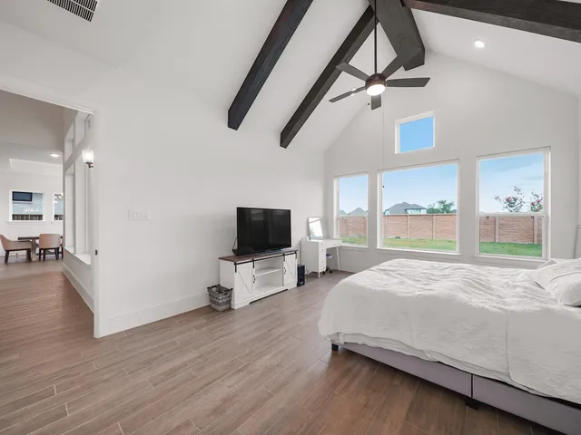 a bedroom with a bed window and a flat screen tv
